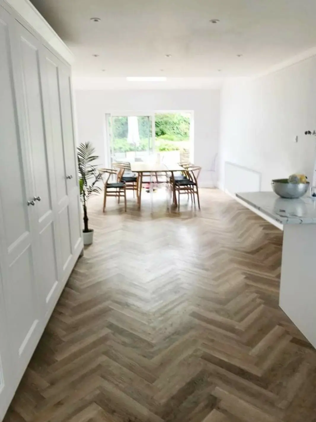 Renovated open-plan kitchen-diner with herringbone flooring